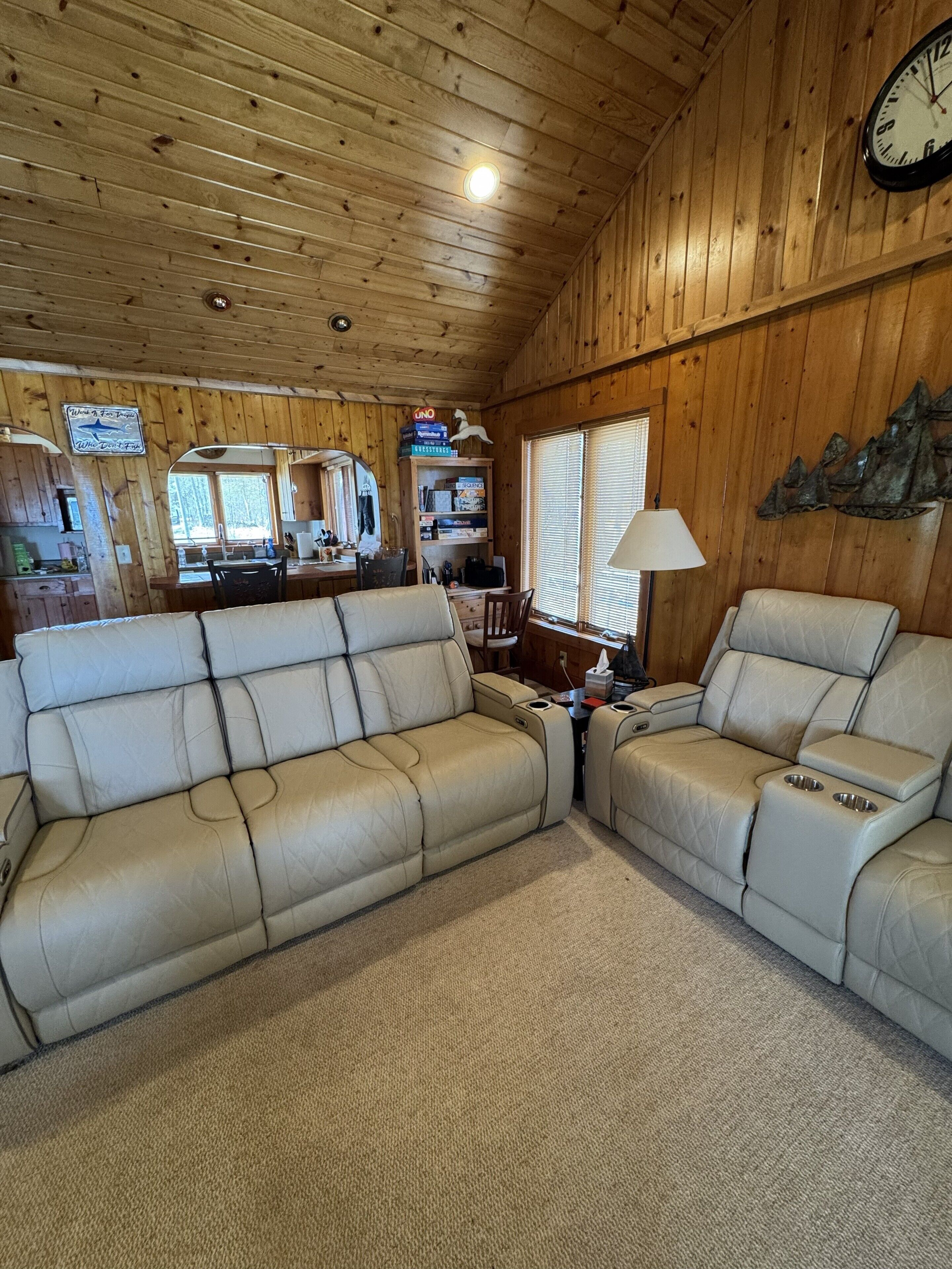 L’intérieur d’une cabine est doté d’un plafond en bois, d’un coin repas et de deux canapés en cuir beige.