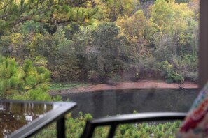 A view of a forested area with a body of water, likely a lake or river, and a dirt path. - Vacay Getaway - Condo for 8 (Branson)