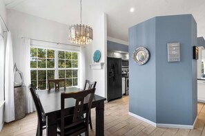 A modern kitchen with a black refrigerator, white cabinets, and a blue accent wall. - Vacay Getaway - Condo for 8 (Branson)