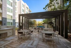 An outdoor patio with wooden flooring, a pergola, and outdoor furniture.
