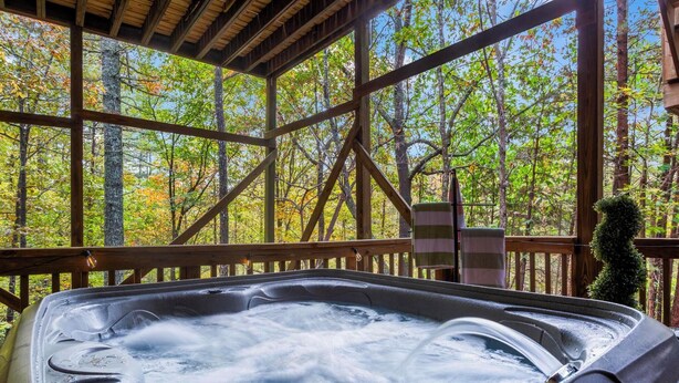 Uma banheira de hidromassagem em uma cabana de madeira com vista para uma floresta.