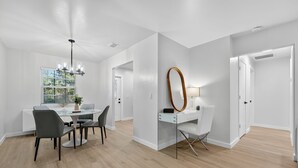 Un espace de salle à manger moderne avec une table ronde, des chaises et un lustre.