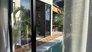 A modern house with large glass doors leading to a pool area.