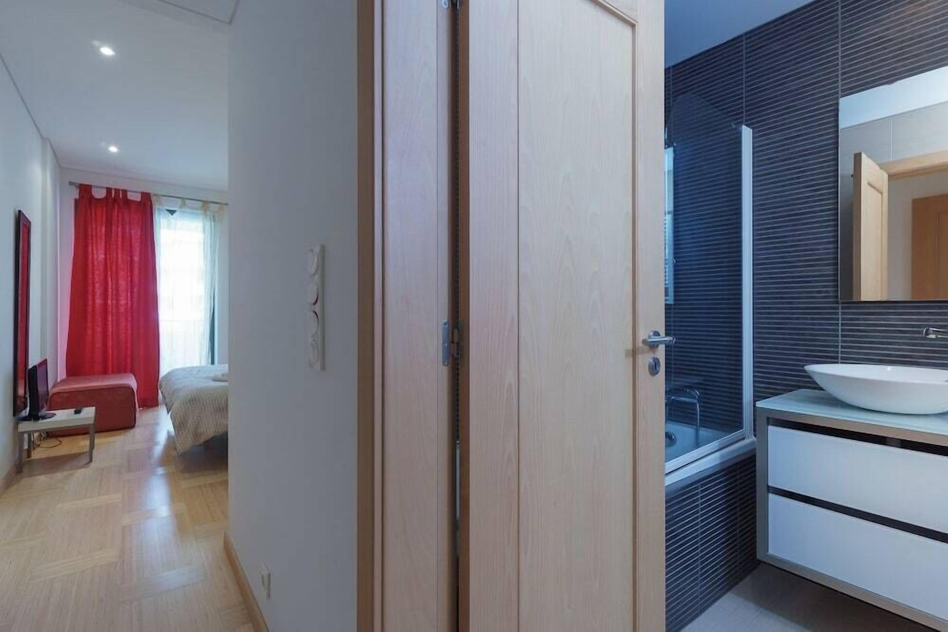 Une salle de bain moderne avec un grand miroir, un lavabo blanc et un espace douche.