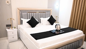 Een moderne slaapkamer met een groot bed, een nachtkastje en een bijzettafeltje.