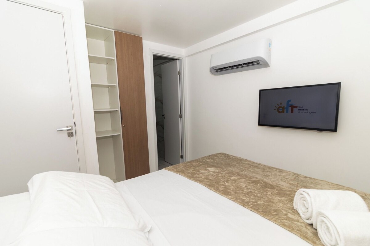 Una camera d'albergo con un letto, un armadio, un condizionatore d'aria e una targa appesa al muro.