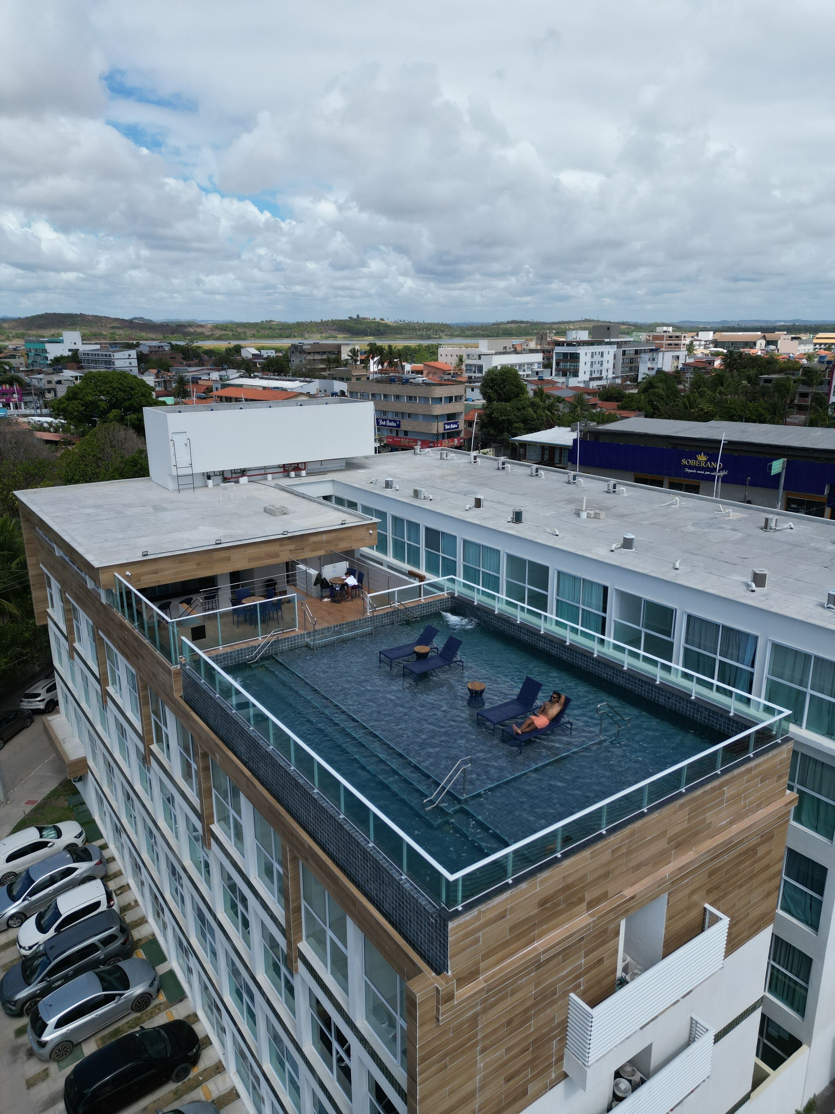 A rooftop pool with lounge chairs and a view of the cityscape.