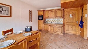 Una cuina compacta amb armaris de fusta i terra de rajola.