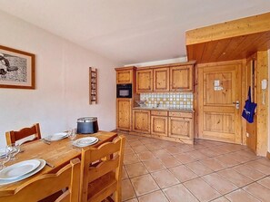 A compact kitchen with wooden cabinets and a tiled floor. - 100m from ski slopes, 2nd floor, swimming pool, tv, ski locker, 63m², Les Menuires (Les Menuires)