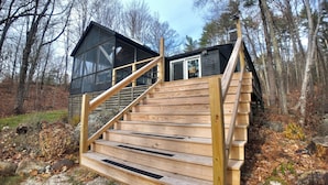 A wooden staircase leading to a cabin with a glass front. - Peaceful Family Friendly Private Lake Waterfront Home Close to Beach and Hiking (Bennington)