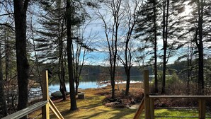 A wooden deck leading to a lake surrounded by trees. - Peaceful Family Friendly Private Lake Waterfront Home Close to Beach and Hiking (Bennington)