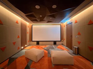 A modern home theater room with a large screen, comfortable seating, and a geometric ceiling design. - Stayshort - Lovely 3 Bed in Downtown Sleeps 5 With Balcony (Dubai)