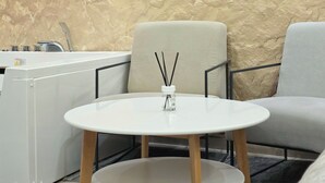 Un intérieur moderne avec une table et des chaises blanches, un petit meuble blanc et un mur à texture.