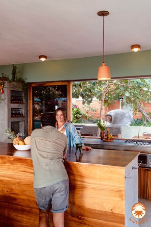 A bar area with a wooden counter, a large window, and a view of the outdoors. - 1 Bed. Villa, Pool, Oceanview (Puerto Ángel)
