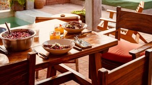 An outdoor dining area with a pool, wooden furniture, and a bed with colorful pillows. - 4 Beds. Villa, Pool, Oceanview (Puerto Ángel)