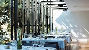 A restaurant with tables set for dining, large windows, and a view of greenery. - Hotel Privo (Târgu Mureș)