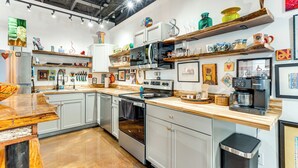 Une cuisine moderne avec des armoires blanches, des appareils en acier inoxydable et des plans de travail en bois.