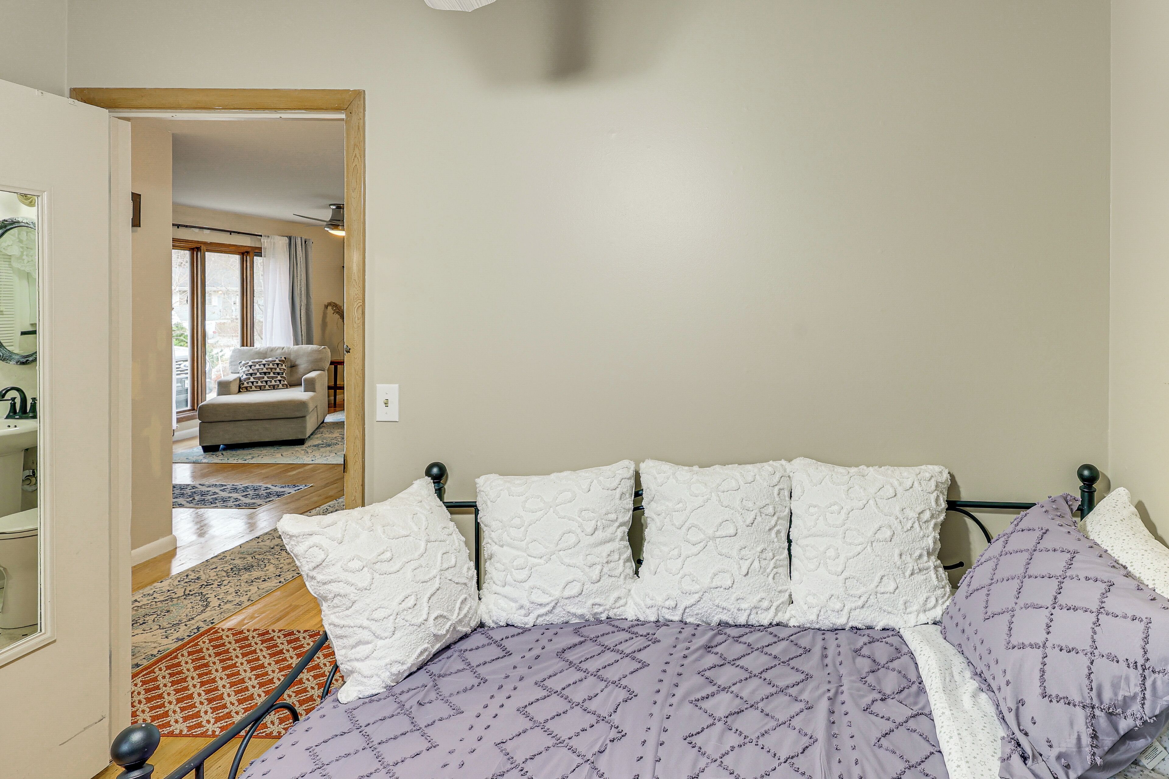 Une chambre à coucher avec un lit, une chaise et une vue sur une autre pièce.