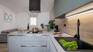 Eine moderne Küche mit Kochinsel, integrierten Geräten und einer Holzrückwand.