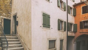Eine schmale Straße mit einem Gebäude, dessen Eingang von einer Treppe aus erreichbar ist.
