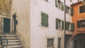 Una calle estrecha con un edificio que tiene una escalera que lleva a una entrada.