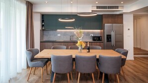 A modern dining area with a wooden table and grey upholstered chairs. - Amazing apartment in Punat with sauna (Punat)
