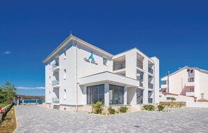 A modern white building with balconies and a sign reading "Villa Porto". - 2 bedroom cozy apartment in Punat (Punat)