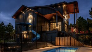 Una casa moderna con piscina, una escalera de caracol y una zona de terraza.