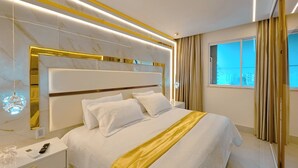 A modern hotel room with a large bed, a bedside table, a mirror, and a window with curtains. - Sofistica o na Gra a Calmaria a 5 min da Barra (Salvador)