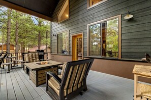 An outdoor patio with a fire pit, seating, and a view of the surrounding forest. - Mogollon Rim Cabin | Hot Tub | Fire Pit (Forest Lakes)