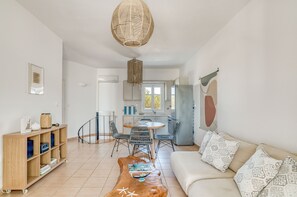 Ein modernes Wohnzimmer mit Sofa, Couchtisch und Essbereich.