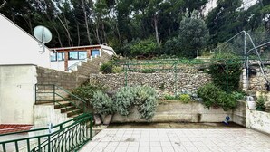 A stone retaining wall with potted plants, a staircase with green railings, and a satellite dish on a building. - Stunning apartment in Drvenik with house sea view (Drvenik)
