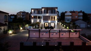 Ein modernes, zweistöckiges Haus mit Balkon, Auffahrt und einem verschlossenen Eingang.