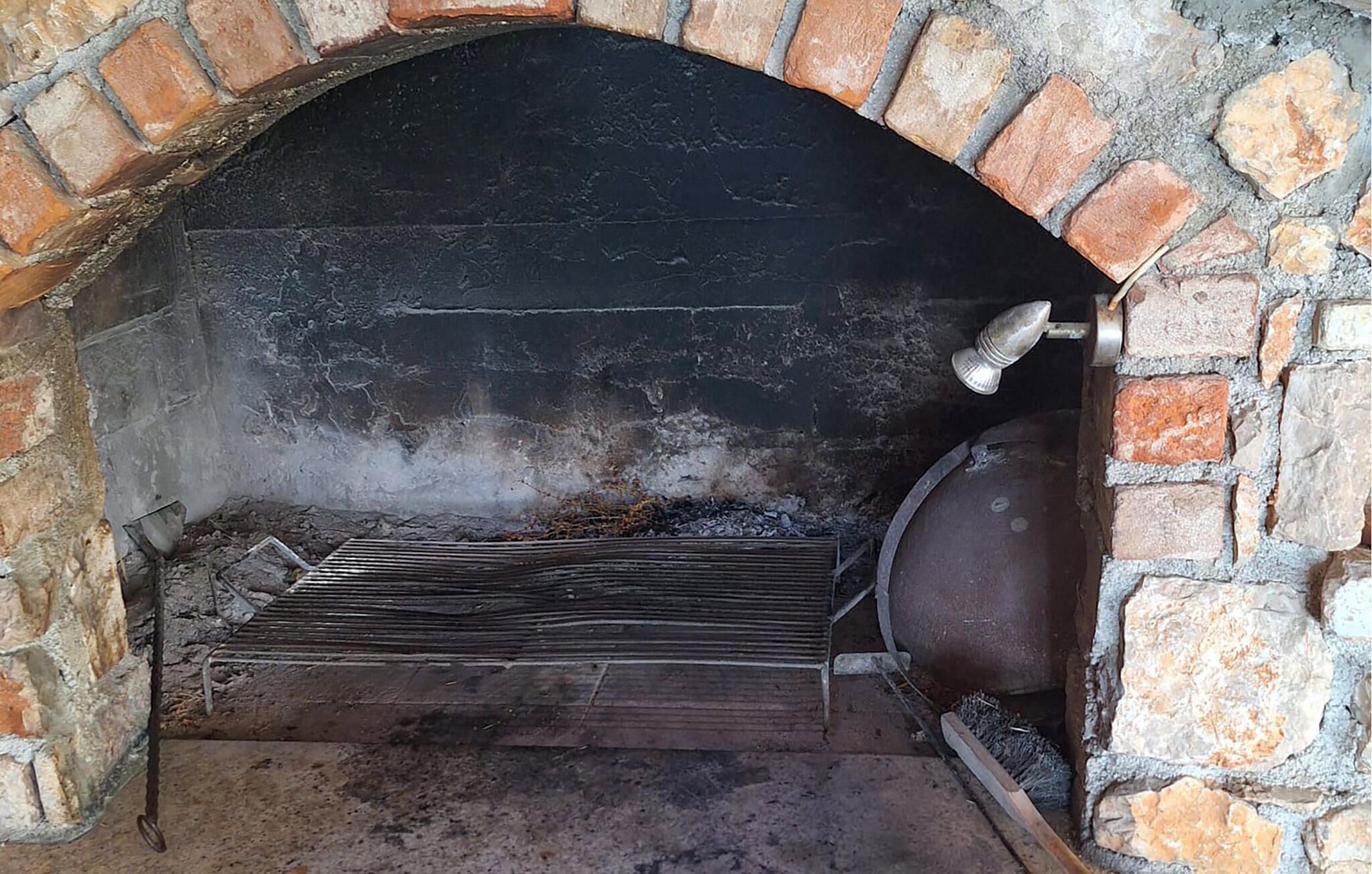 For forn de rajola amb una prestatgeria metàl·lica i una xemeneia.