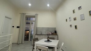 Een moderne keuken met een eethoek, witte muren en plafondlampen.
