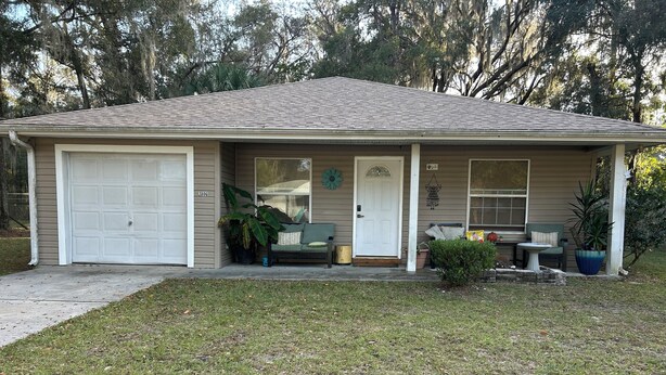 A single-story house with a garage, a front porch with a bench, and a small garden area. - 2 bed 2 bath home in Ocala Fl
Front porch
Screened back porch
Cozy home (Ocala)