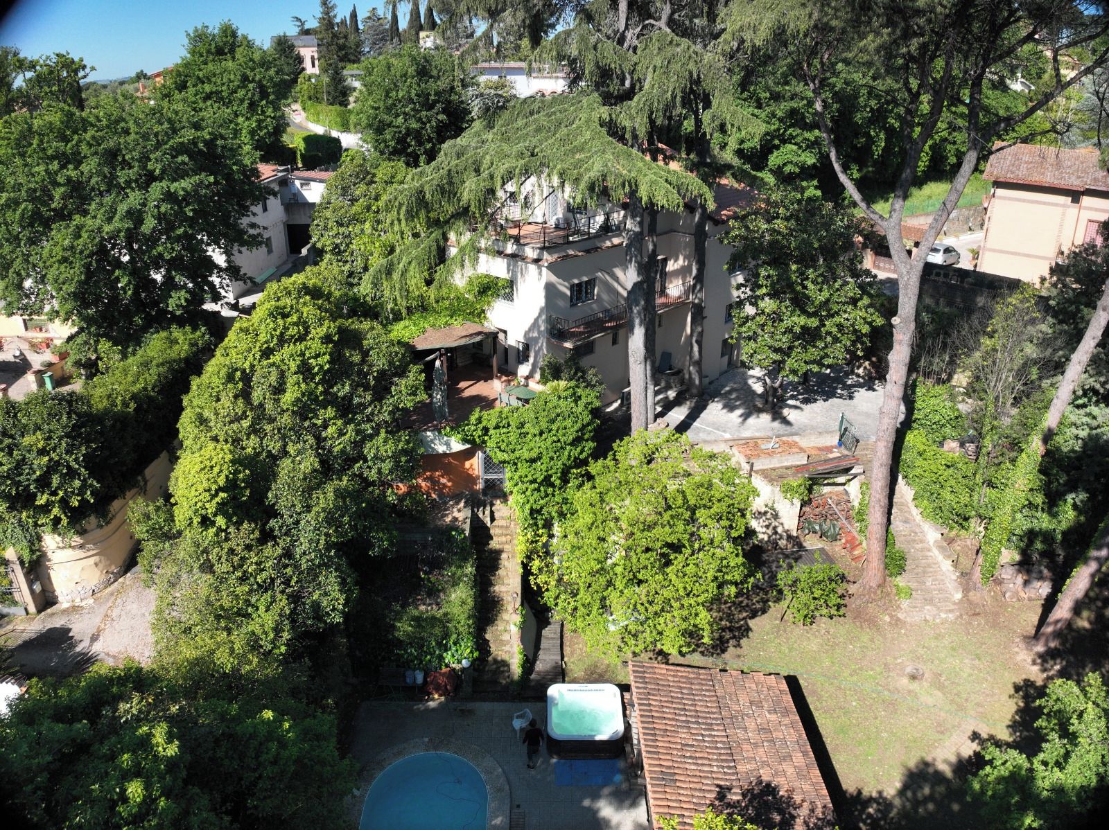 Ein Wohngebiet mit Swimmingpool, Bäumen und einem Gebäude mit Balkon.