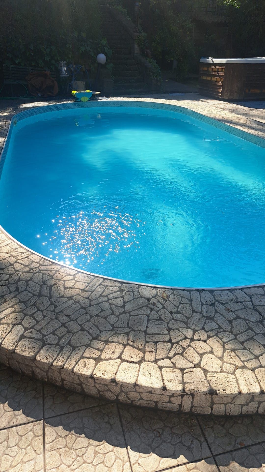 Ein Schwimmbecken mit Steinplattenbordur.