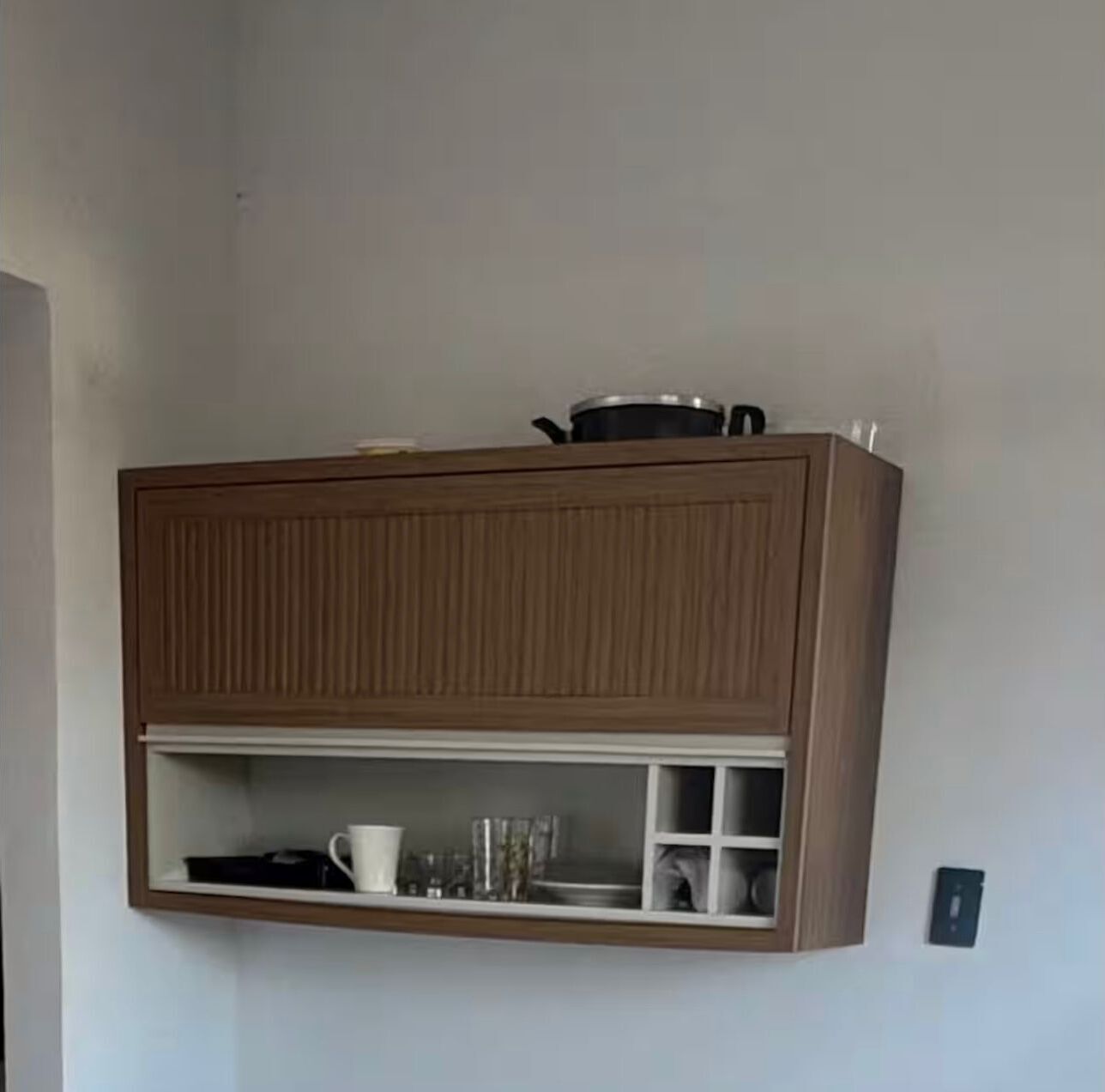 Een keuken met houten kastjes, een aanrecht en een pan erbovenop.