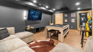 A modern living room with a pool table, a large flat-screen TV, and a cozy seating area. - Black Diamond Retreat 7BR Sleeps 18 Hot Tub+Sauna 3 Min to Massanutten Slopes (McGaheysville)