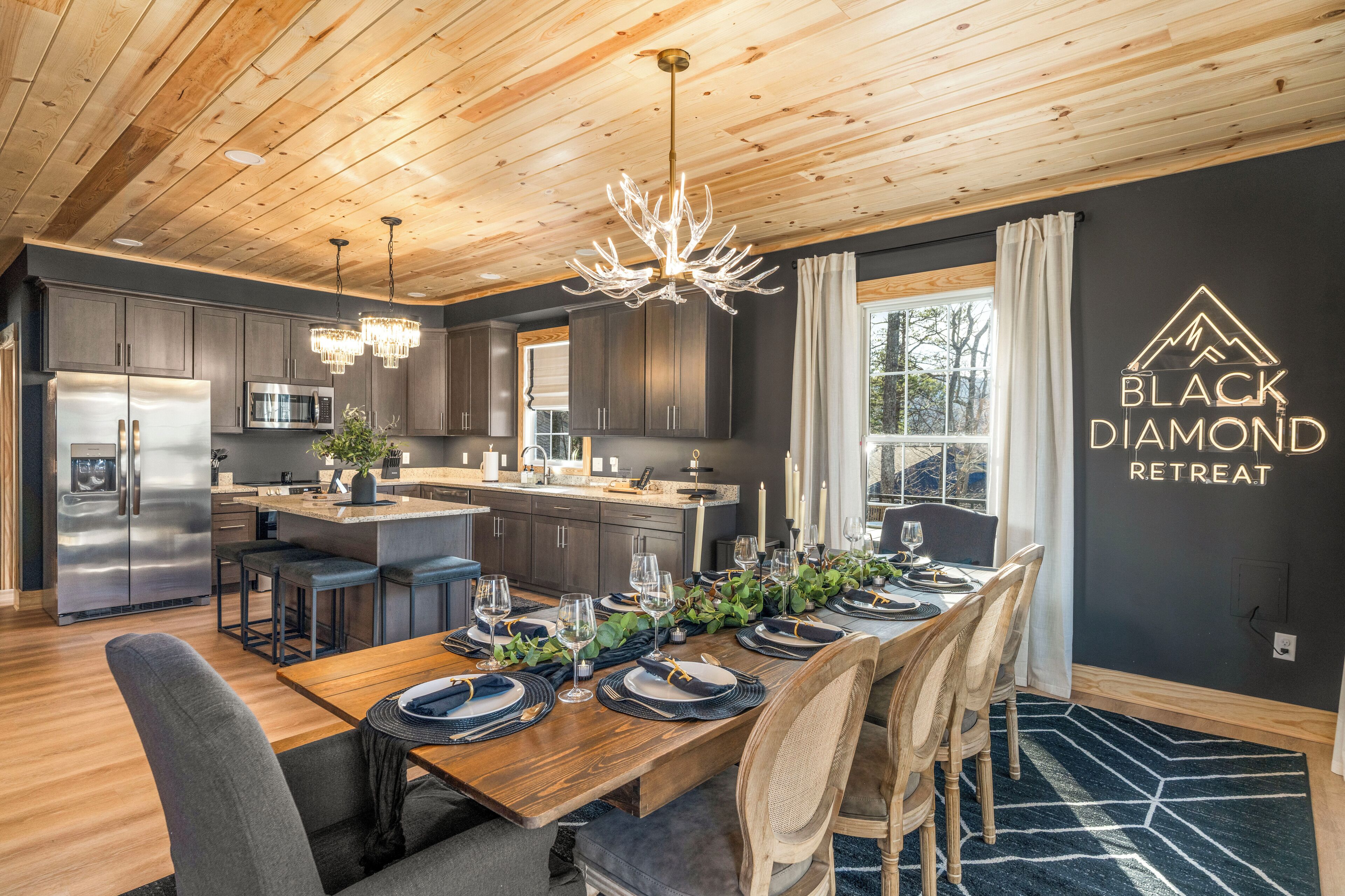 A modern kitchen with dark cabinets, stainless steel appliances, and a central island.