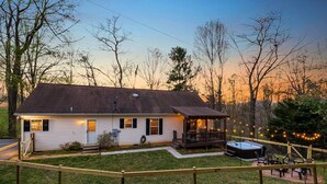 Ein eingeschossiges Haus mit überdachter Veranda, Whirlpool und umzäunter Garten.