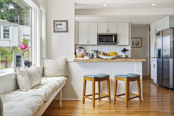 A modern kitchen with white cabinets, a built-in microwave, and a stainless steel refrigerator. - Boothbay Harbor King Suite - Room 2 at Greenleaf Inn - Balcony, Harbor Views! (Boothbay Harbor)