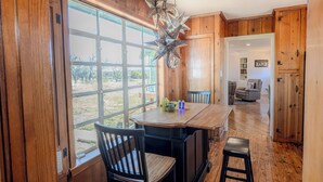 A kitchen with wooden cabinets, a large window, and a hanging star-shaped light fixture.
