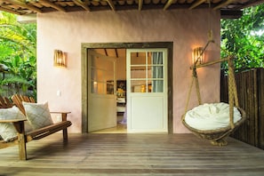 A wooden deck with a hanging chair and a bench. - UXUA Alma (Porto Seguro)