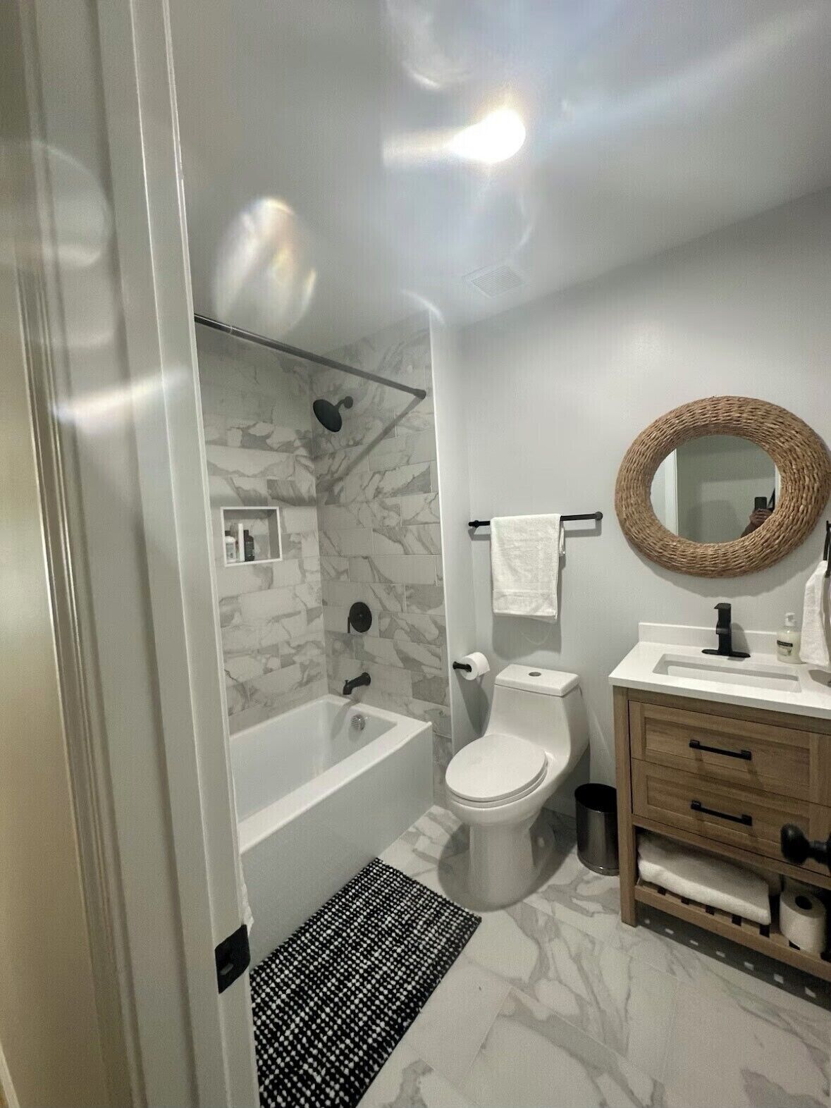 Une salle de bain moderne équipée d’une baignoire, de toilettes et d’un meuble-lavabo.