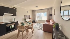 Een modern appartement met keuken, eethoek en woonkamer.