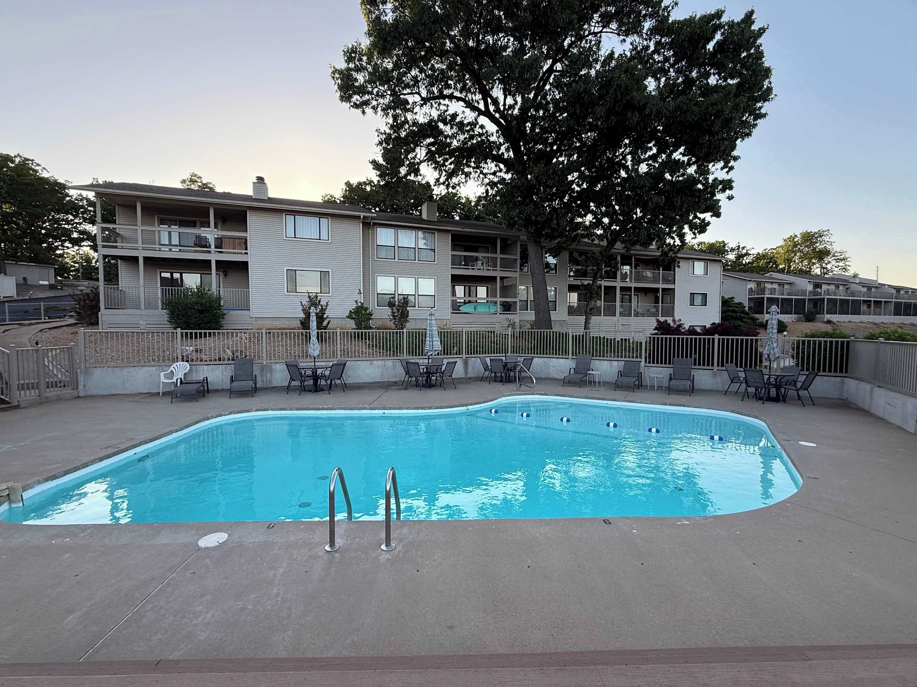 A rectangular pool with two metal ladders, surrounded by a concrete deck.