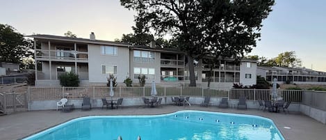 A rectangular pool with two metal ladders, surrounded by a concrete deck.