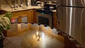 Une cuisine dotée de meubles en bois, d’appareils électroménagers en acier inoxydable et d’un plan de travail réfléchissant.